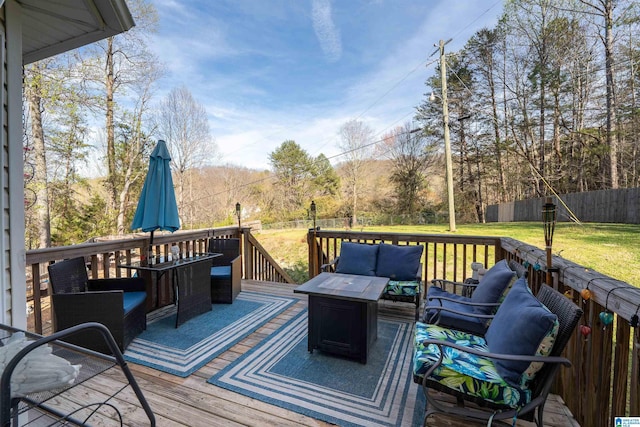 wooden deck with outdoor lounge area, fence, and a lawn