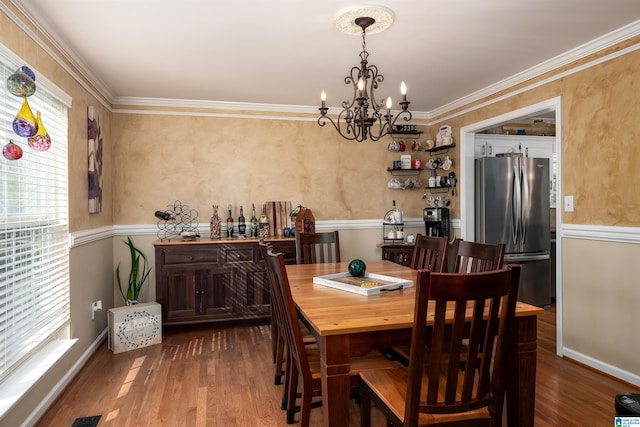 dining room featuring a notable chandelier, crown molding, and dark wood-style floors