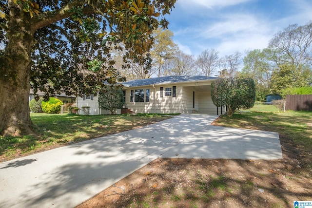 view of front of house featuring a front yard, driveway, a carport, and fence