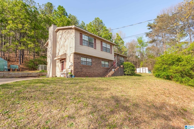 view of front of property with an outdoor structure, brick siding, a front yard, and a chimney