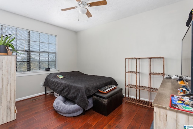 bedroom featuring a textured ceiling, baseboards, visible vents, ceiling fan, and hardwood / wood-style floors