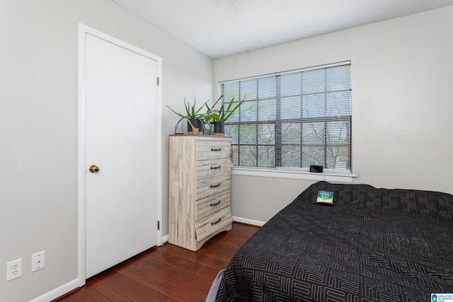 bedroom featuring dark wood-type flooring, baseboards, and a textured ceiling