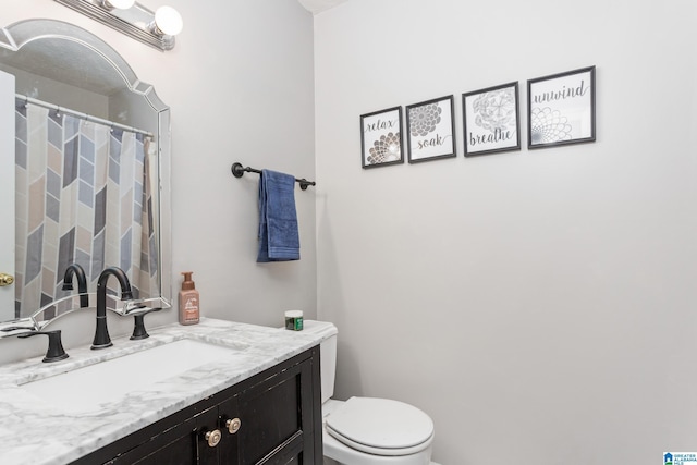 bathroom featuring toilet, vanity, and curtained shower