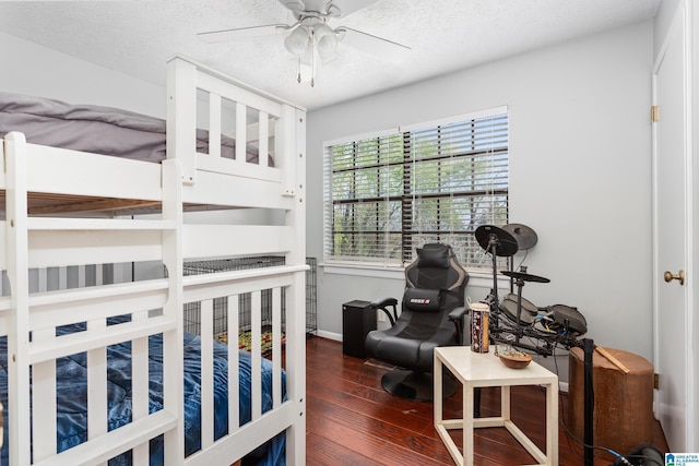 bedroom with baseboards, a ceiling fan, wood finished floors, and a textured ceiling
