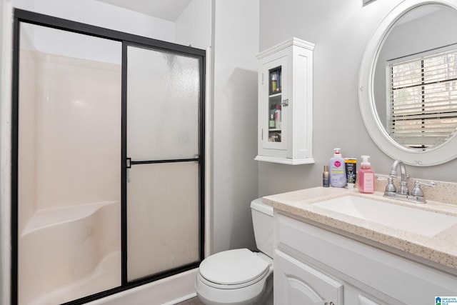 bathroom with vanity, toilet, and a shower stall