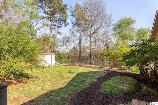 view of yard featuring a fenced backyard, an outbuilding, and a shed