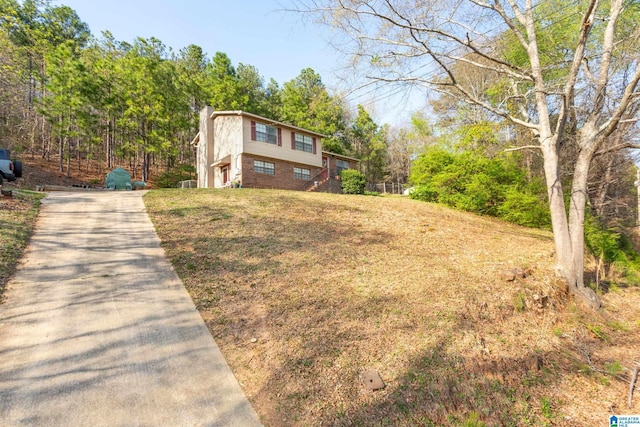 view of front facade with a front yard, concrete driveway, and a chimney