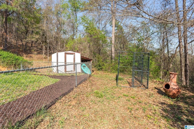 view of yard featuring an outbuilding, a shed, fence, and a detached garage