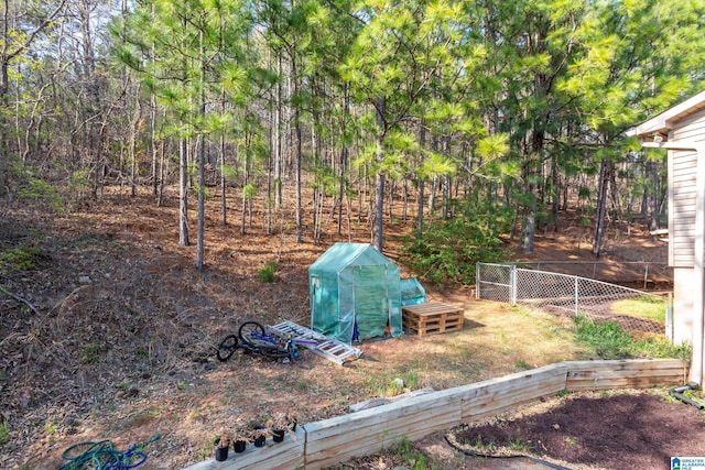 view of yard featuring an outdoor structure and fence
