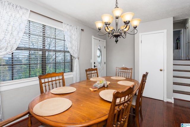 dining area with hardwood / wood-style floors, a notable chandelier, stairway, and a textured ceiling