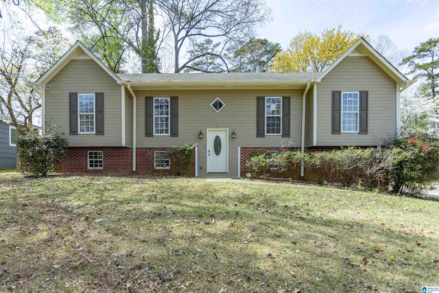 raised ranch featuring a front yard and brick siding