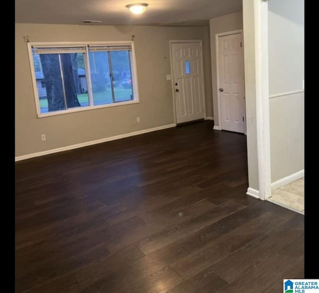 foyer entrance featuring dark wood-type flooring and baseboards
