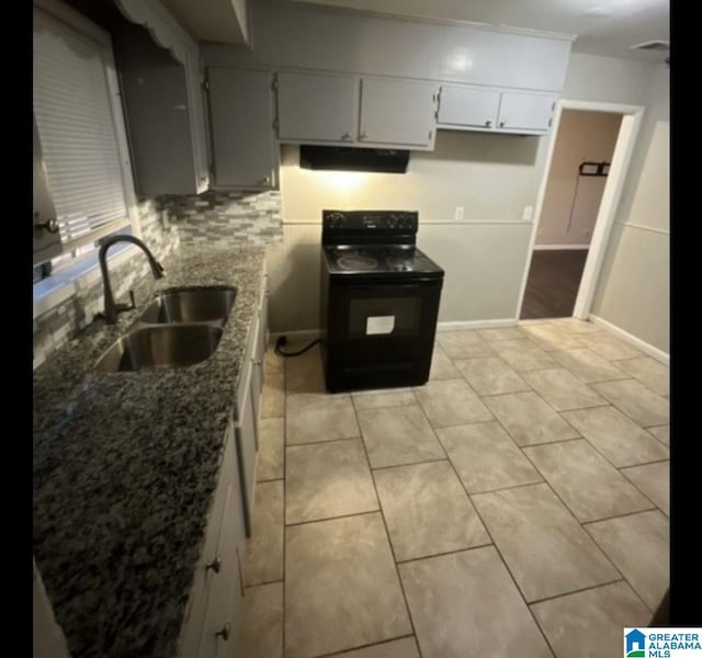 kitchen with black / electric stove, a sink, exhaust hood, dark stone counters, and light tile patterned floors