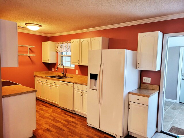 600 Mayfair Ln, Cullman, AL 35057 - kitchen featuring white appliances, ornamental molding, a textured ceiling, a sink, and wood finished floors