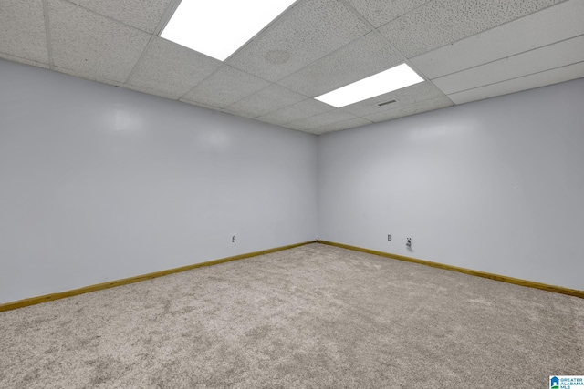 spare room with baseboards, carpet flooring, and a drop ceiling