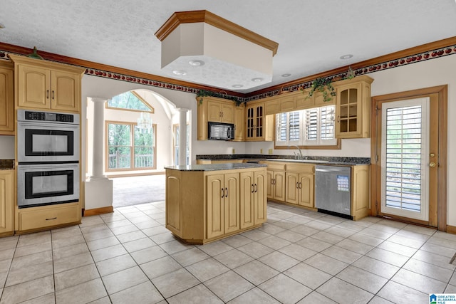 kitchen with a kitchen island, stainless steel appliances, dark countertops, and decorative columns