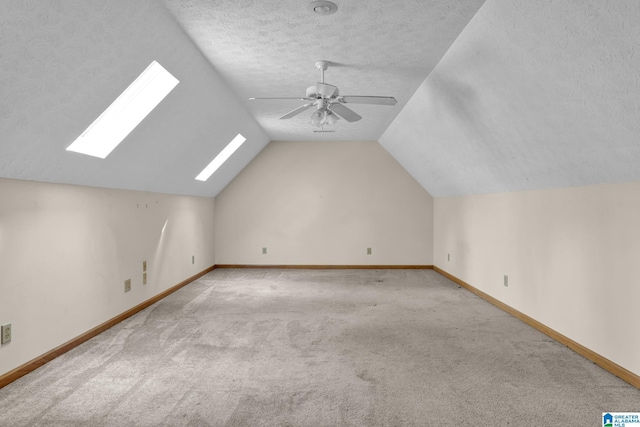 additional living space featuring baseboards, carpet floors, a textured ceiling, and a ceiling fan