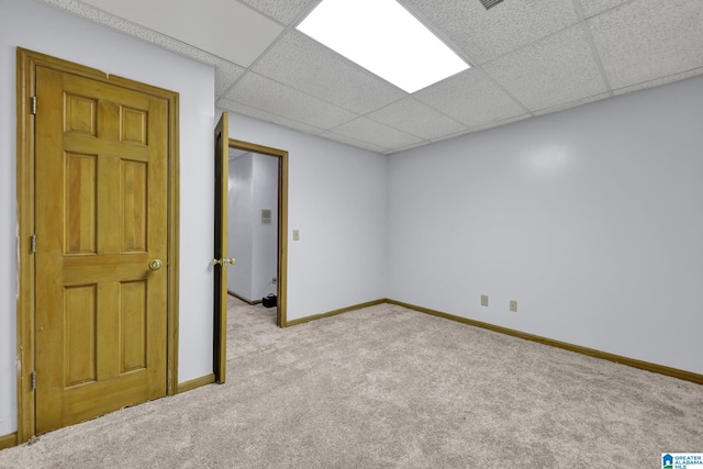 interior space with baseboards, a paneled ceiling, and carpet