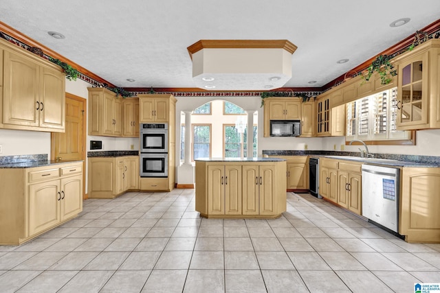 kitchen featuring stainless steel appliances, glass insert cabinets, a sink, a center island, and light tile patterned floors