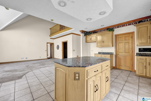 kitchen featuring a kitchen island, light carpet, open floor plan, light tile patterned floors, and baseboards