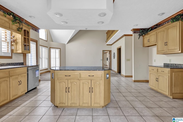 kitchen with a center island, glass insert cabinets, dishwasher, and light tile patterned floors