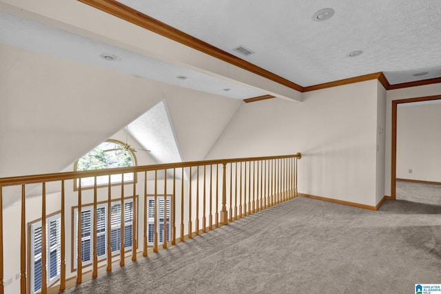 corridor featuring crown molding, vaulted ceiling, carpet, baseboards, and visible vents