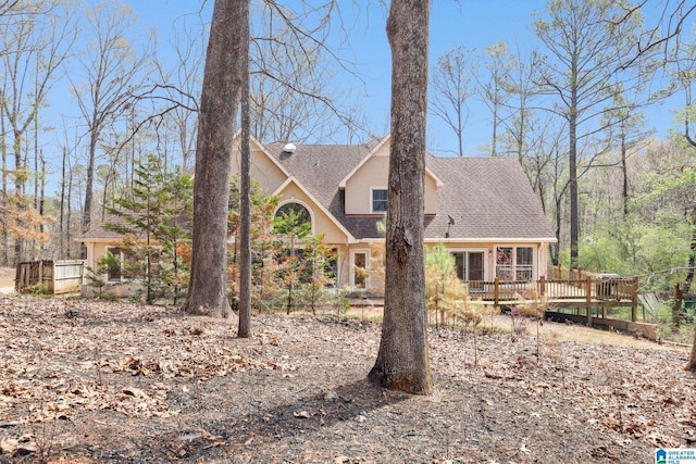 view of front of property with roof with shingles and a deck