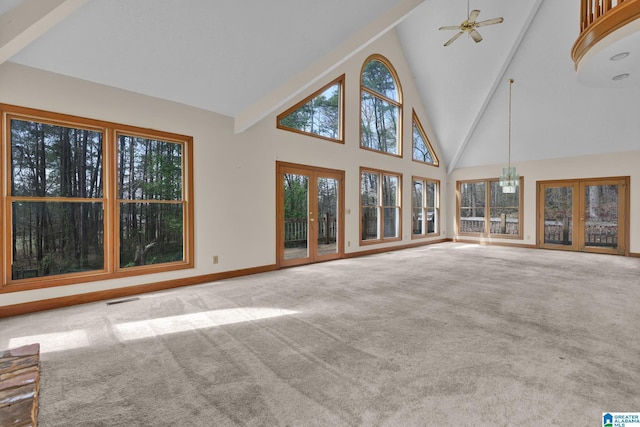 unfurnished living room with french doors, visible vents, ceiling fan, and carpet flooring