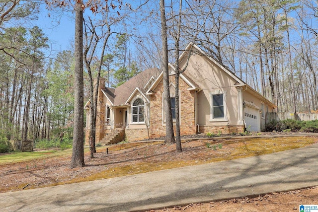view of front of house with stucco siding, stone siding, and a garage