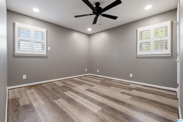 unfurnished room featuring a ceiling fan, baseboards, a healthy amount of sunlight, and wood finished floors