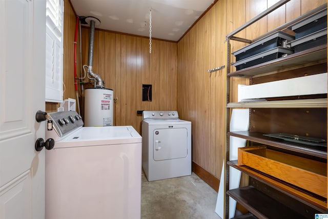clothes washing area with water heater, independent washer and dryer, wooden walls, and laundry area