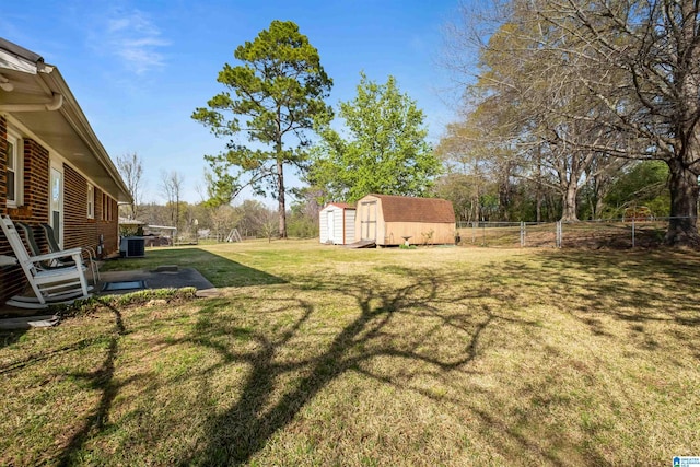 view of yard featuring an outdoor structure, cooling unit, a storage unit, and fence
