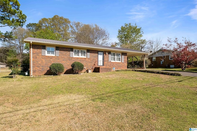 ranch-style home featuring brick siding, metal roof, a front yard, and a carport