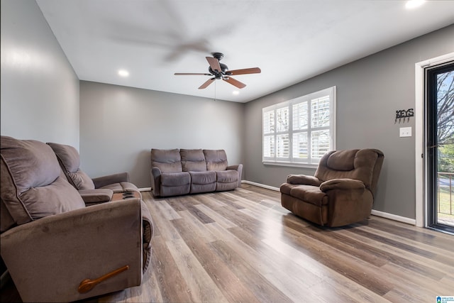 living area with baseboards, ceiling fan, recessed lighting, and light wood-type flooring