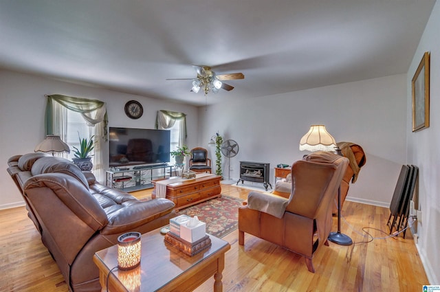 living room with ceiling fan, baseboards, and light wood-style floors