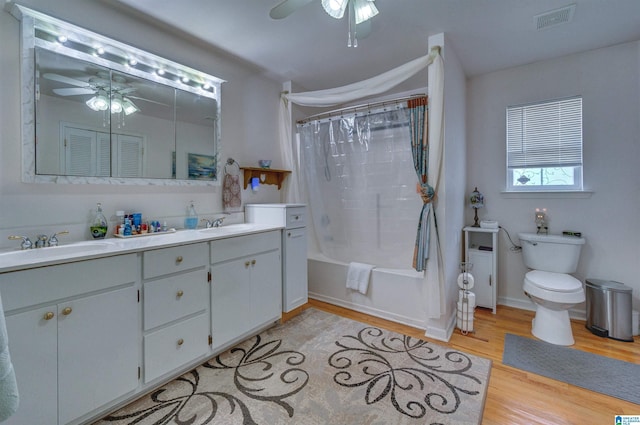 full bath with toilet, ceiling fan, wood finished floors, and visible vents