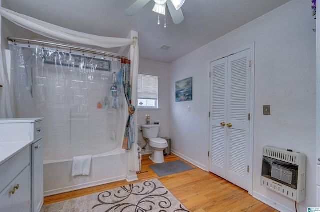 bathroom featuring heating unit, ceiling fan, toilet, visible vents, and wood finished floors