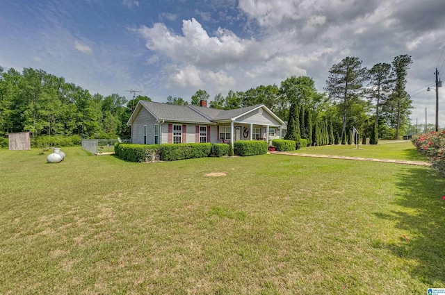 ranch-style house with a porch, a front yard, and a chimney