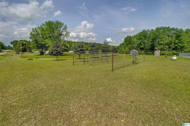 view of yard featuring a storage unit, fence, and an outdoor structure
