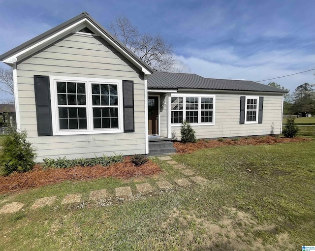 view of front of home featuring a front lawn and metal roof