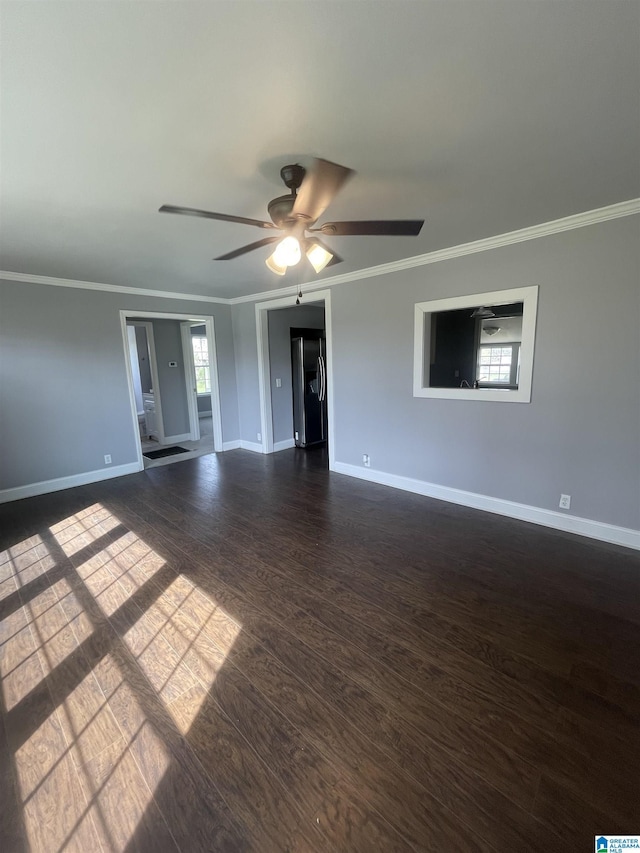 unfurnished room featuring dark wood-style floors, baseboards, and crown molding