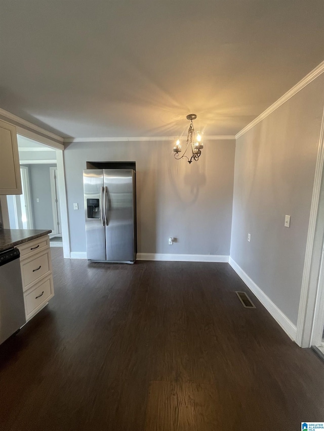 unfurnished dining area with baseboards, visible vents, ornamental molding, dark wood-type flooring, and an inviting chandelier