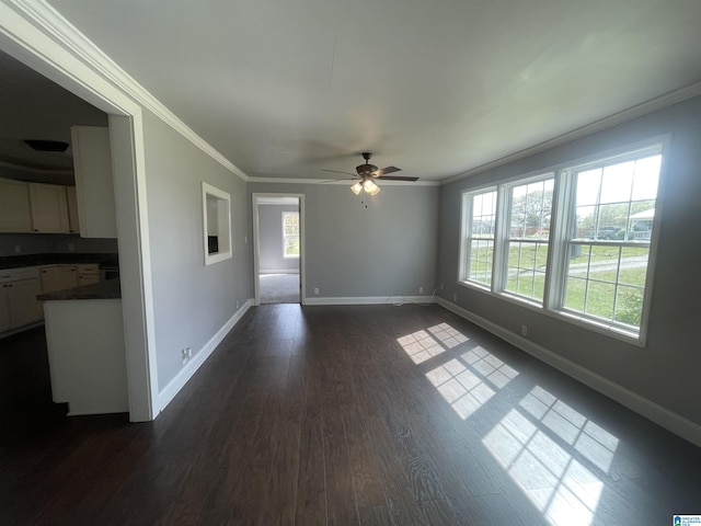 unfurnished room with baseboards, dark wood-style floors, a healthy amount of sunlight, and crown molding