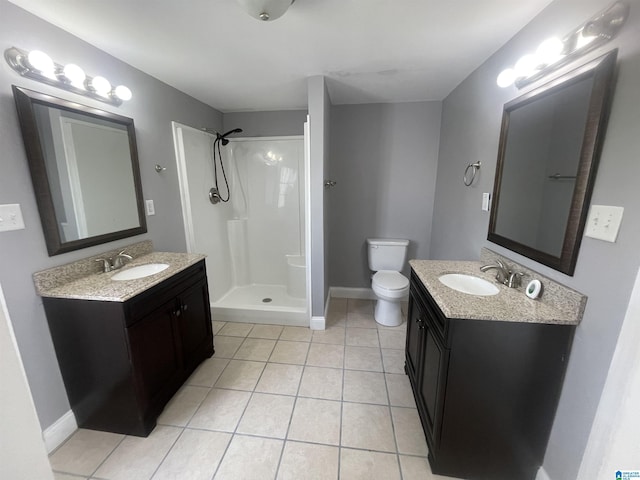 full bathroom featuring a shower stall, tile patterned flooring, a sink, and two vanities