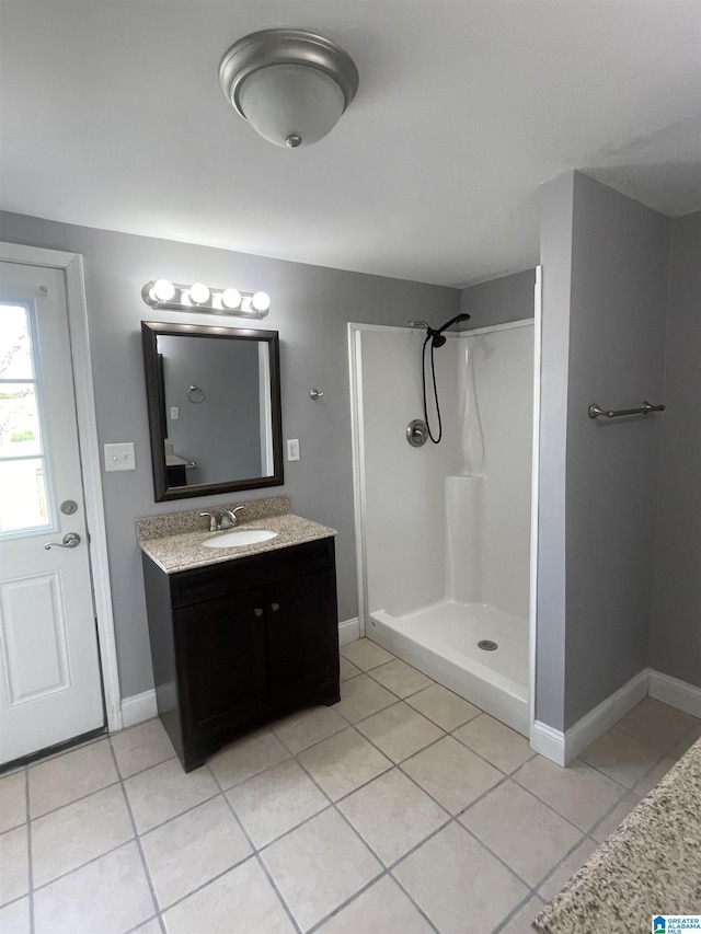 full bath with baseboards, a shower, tile patterned flooring, and vanity