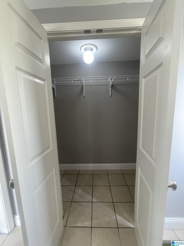 walk in closet with light tile patterned flooring