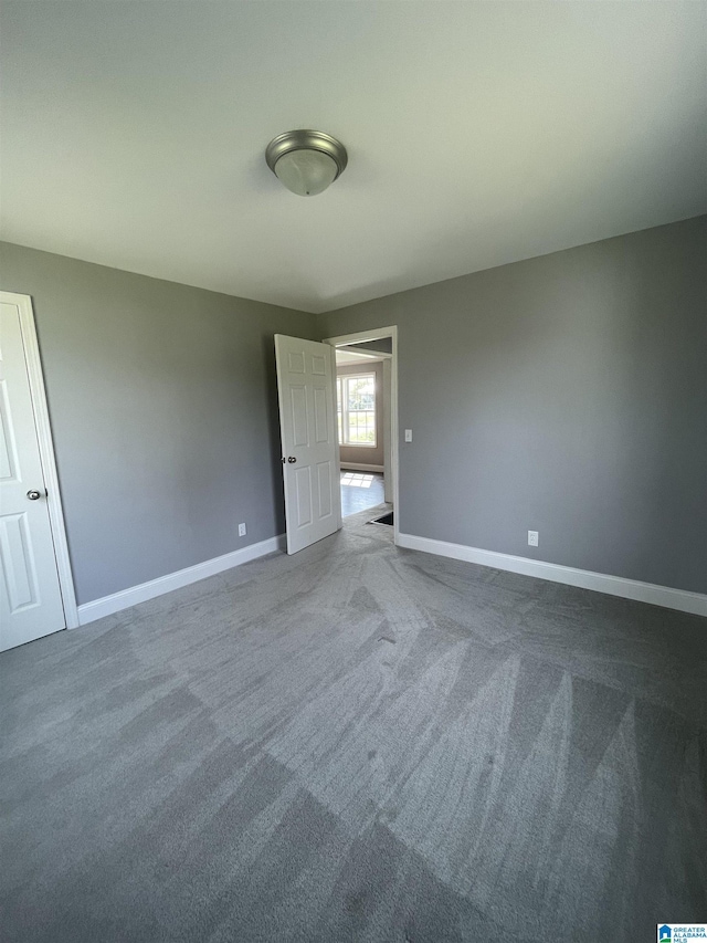 unfurnished bedroom with baseboards and carpet