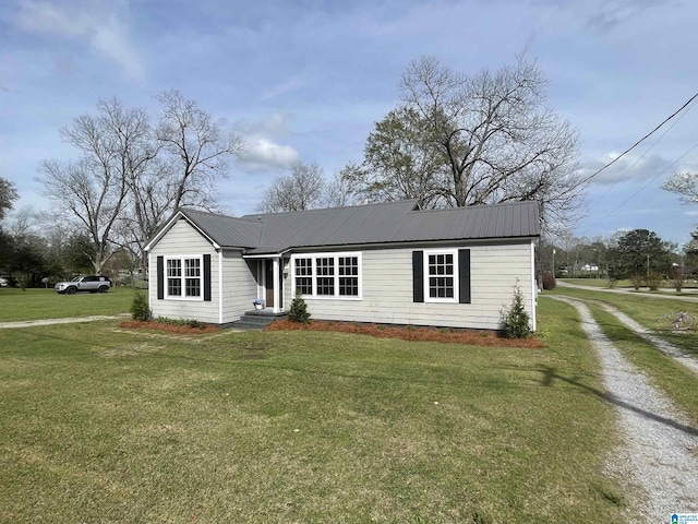 view of front of house featuring metal roof and a front lawn