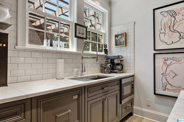 4603 Clairmont Ave, Birmingham, AL 35222 - bar with stainless steel microwave, a sink, baseboards, and decorative backsplash