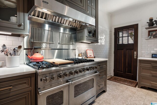 4603 Clairmont Ave, Birmingham, AL 35222 - kitchen featuring light countertops, ornamental molding, decorative backsplash, range with two ovens, and ventilation hood